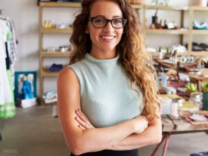 Curly haired model with mint turtleneck and glasses esprit® cosmetic surgeons